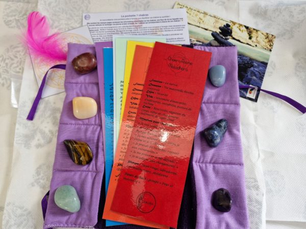 Pochette artisanale avec pierres naturelles des 7 chakras, fleur de vie et marque-pages explicatifs.