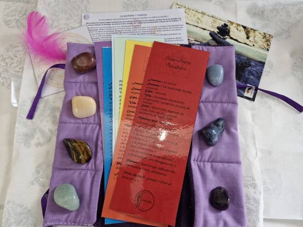 Pochette artisanale avec pierres naturelles des 7 chakras, fleur de vie et marque-pages explicatifs.